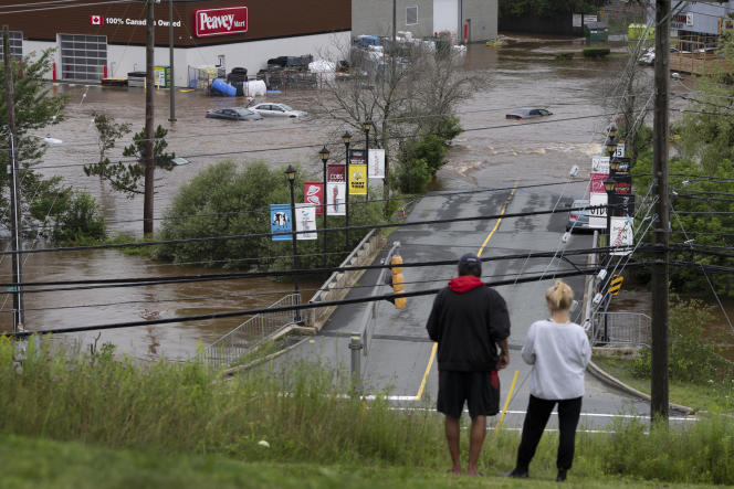 Dos personas apostadas en una colina observan las inundaciones que se están desarrollando en la ciudad de Halifax en Nueva Escocia en Canadá, el 22 de julio de 2023. 