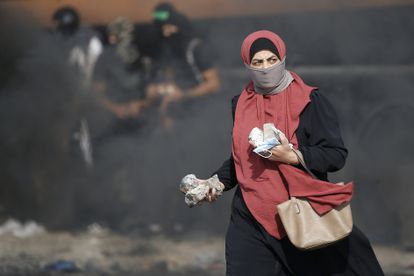Una mujer con piedras en la mano durante un choque entre palestinos y fuerzas israelíes en la entrada norte a Ramala (Cisjordania), el 20 de octubre.