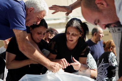 Varios cristianos sollozan ante los cadáveres de las víctimas del bombardeo israelí que dañó parte de la iglesia de San Porfirio de Gaza, el 20 de octubre.